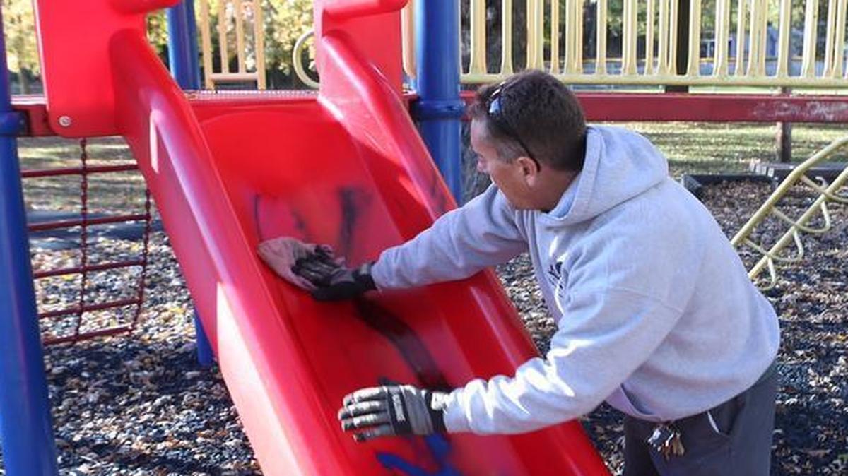 Belleville Parks and Recreation maintenance worker Rich Geissler on Oct. 30 removes racist graffiti from playground equipment at South Side Park.