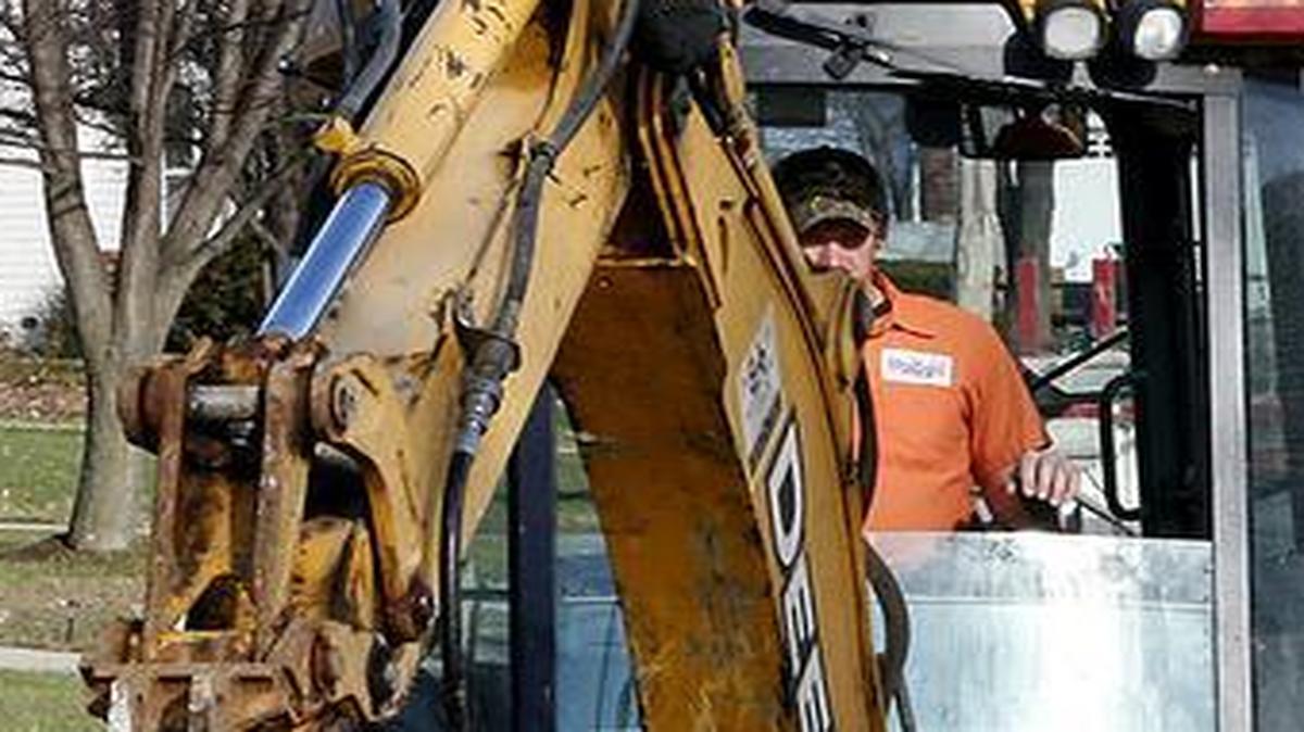 Collinsviile Street Department foreman Mike Delaney and his crew work to repair some cracked spots Wednesday on Cedar Ridge Court in Collinsville. Road repairs are one issue driving the push for a utility tax increase.