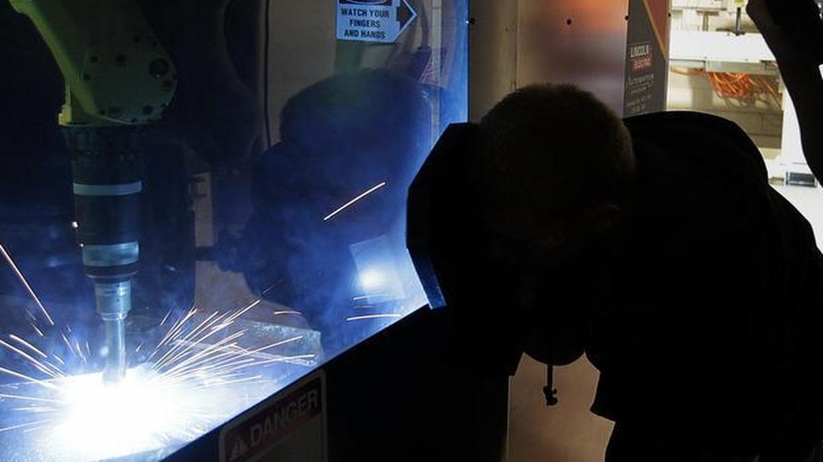 Triad High School students use protective welding masks in 2014 to watch a demonstration of this robotic welder at the Sam Wolf Campus of Southwestern Illinois College in Granite City. About 3,000 industrial and trade jobs are expected to open in the area within five years.
