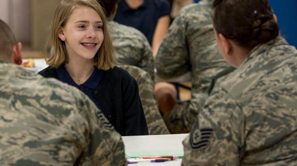 Tech. Sgt. Carla Boehm, 375th Communications Squadron security manager, interviews a middle school student during St. Clare Catholic School’s science fair Feb. 22, 2018 in O’Fallon, Illinois. Scott Air Force Base sent about 30 volunteers to help grade and interview the St. Clare students on their science projects. (Photo by Airman 1st Class Tara Stetler/U.S. Air Force)