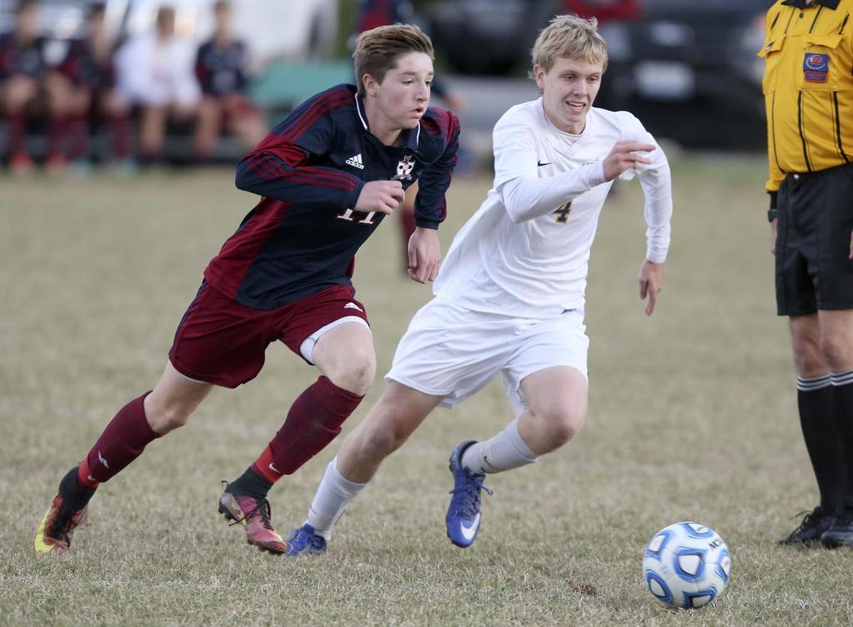 Gibault’s Karson Huels and Althoff’s Mitchell Kidd sprint to the ball during the Class 1A soccer sectional championship in 2017.