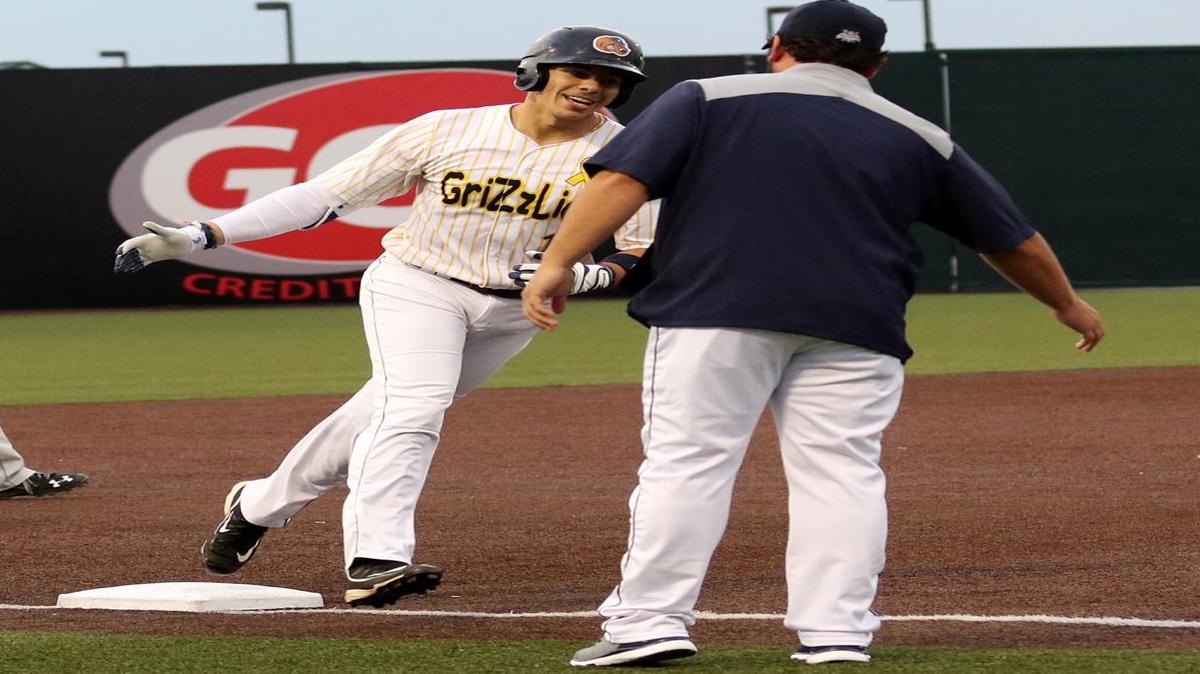 Ramon Osuna of the Grizzlies slaps the hands of Manager Phil Warren after hitting a two run home run against Joliet.