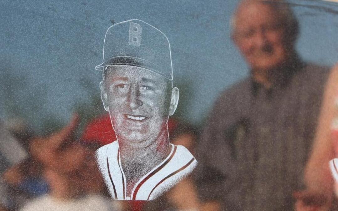 Barney Elser is reflected in a plaque honoring him and fellow Hilgard coach John Schmidt. photo by Zia Nizami