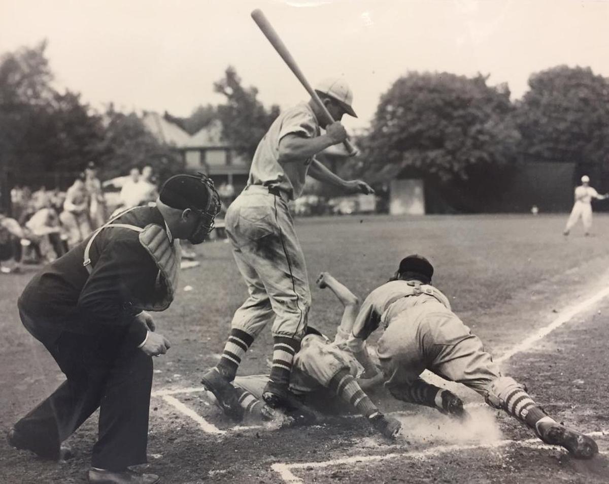 Barney Elser slides in home as a member of the Belleville Township High School baseball team in 1949. The batter, jumping out of the way, is Bob Goalby, who would go on to 11 Pro Golfers Tour wins including the 1968 Masters championship. The BTHS team won the state championship that season. Elser, a sophomore, set a standing record with three doubles in an Illinois title game.