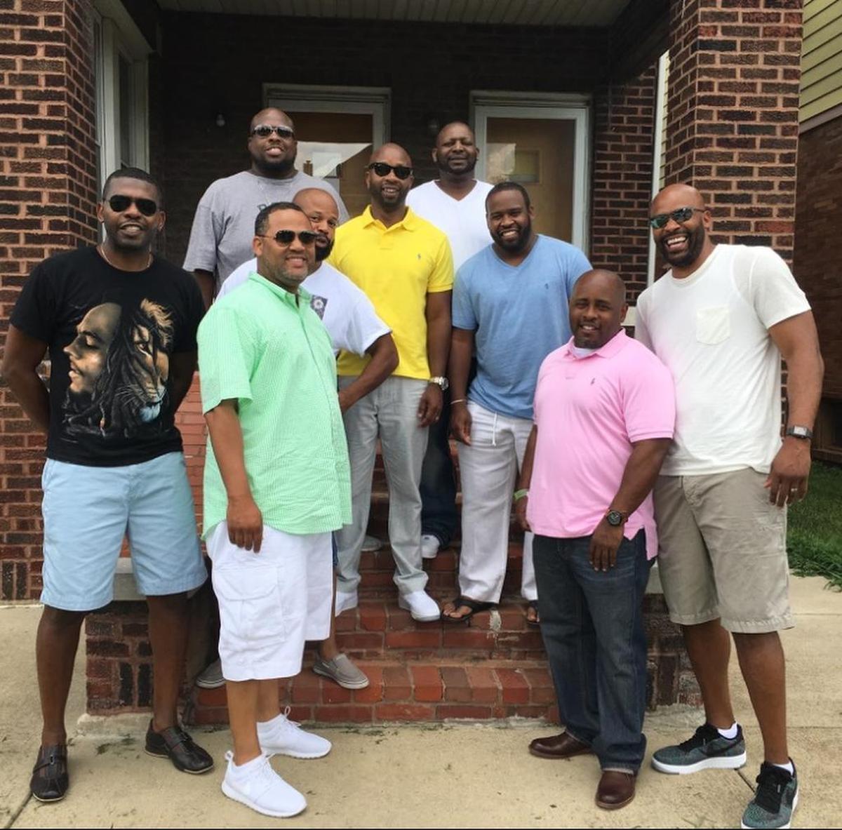 Cuonzo Martin (far right) and Marco Harris (center, yellow shirt) stand among friends, including Rico Sylvester Sr. (front, middle left), on the front steps of Norman Stevens’ East St. Louis home. The men grew up hanging out at Stevens’ duplex, mostly in the basement, and Martin lived here during high school because he and Harris didn’t like spending time apart.