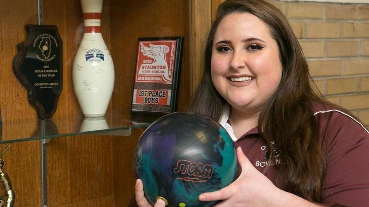 Dupo High School bowler Courtney Argus stands next to one of her bowler of the year awards.