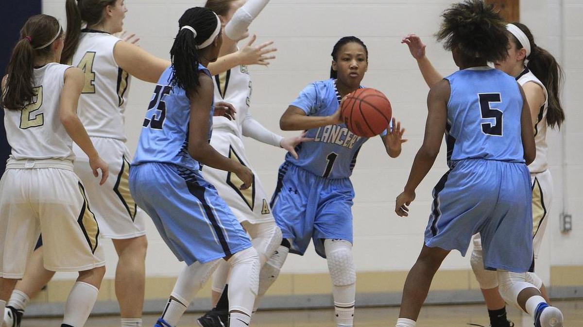 Belleville East’s Kaylah Rainey (1) passes as she is surrounded by several Althoff players and some of her own teammates early in the game.