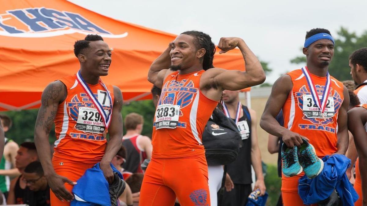 East St. Louis’ Roosevelt Davis celebrates with teammates and fans after winning the Class 3A 100 meter relay championship at the IHSA Track and Field State meet on Saturday in Charleston.
