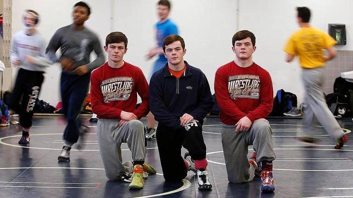 Althoff Catholic High School wrestling brothers from left: Jarrid Braunagel, Danny Braunagel and Zac Braunagel as they prepared for the IHSA state meet last season. Jarrid Braunagel has graduated, but twins Danny and Zac are back to defend their state championships.