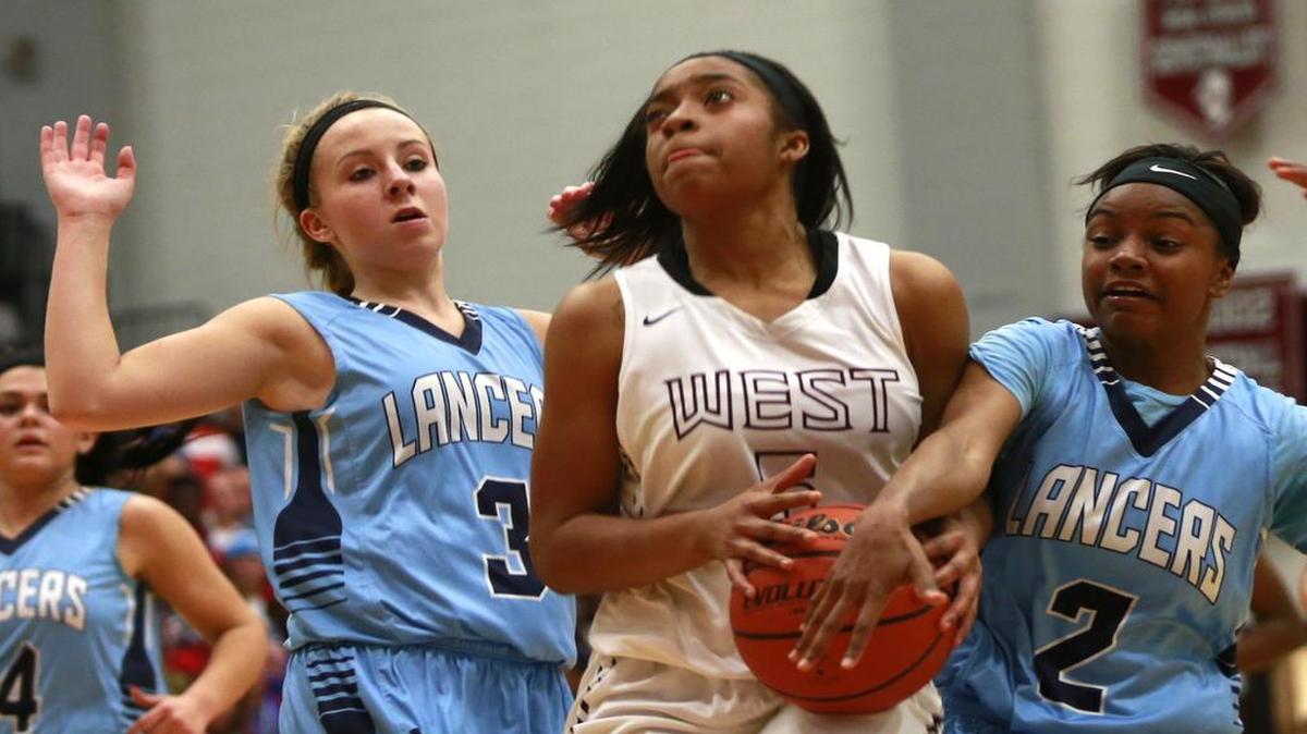Belleville East’s Jailyn McClenny moves in to steal the ball from Belleville West’s Chamya Darough during their game at Belleville West on Tuesday. Also pictured is Belleville East’s Brittney Nitz.