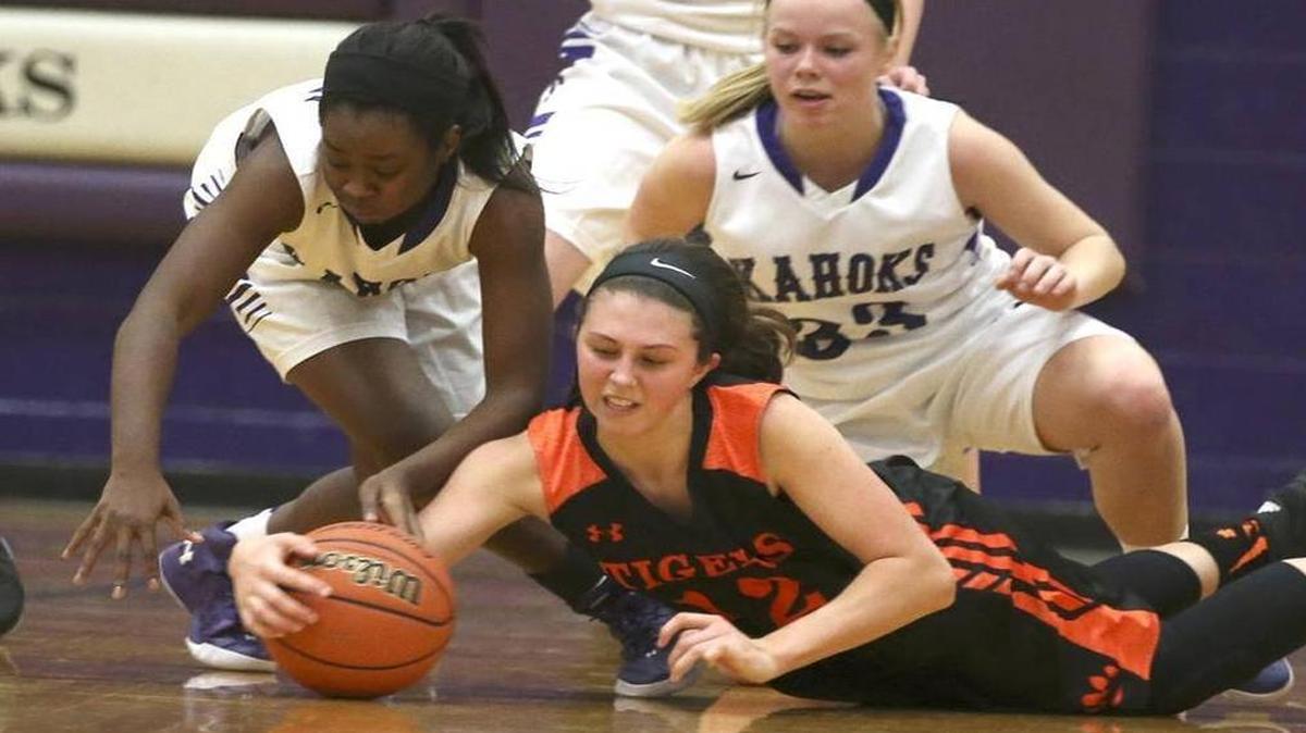 Edwardsville's Makenzie Silvey dives to grab a loose ball against Collinsville's Venise Govan and Carlee Mahan.