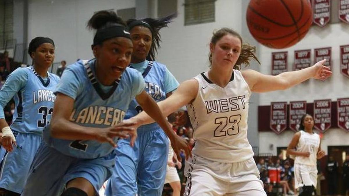 Jaily McClenny and Sydney Thurwalker battle for a loose ball during their game last season. The two are not teammates at Belleville East.