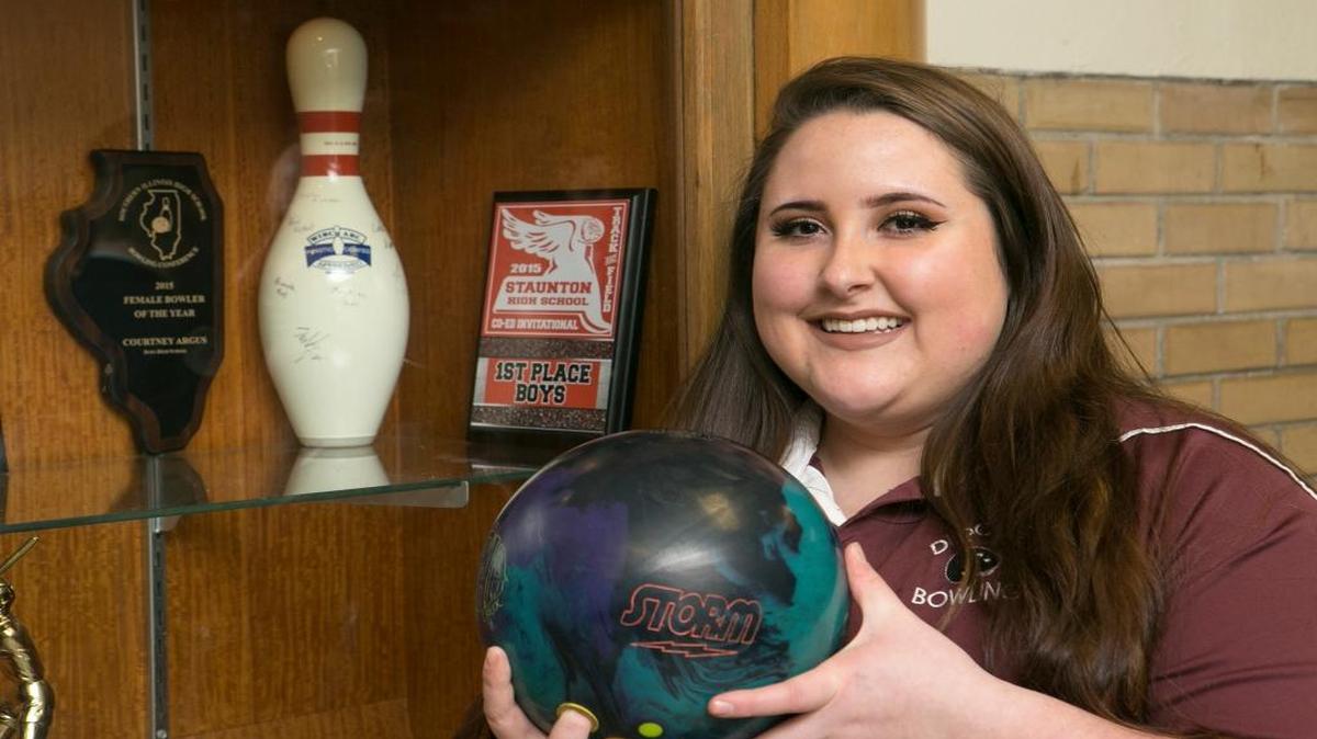Dupo High School bowler Courtney Argus stands next to one of her bowler of the year awards.