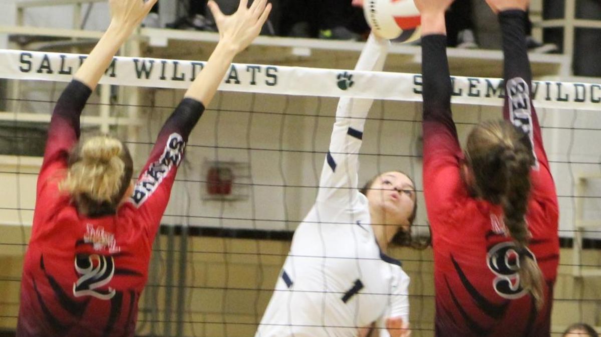 Althoff sophomore Katie Wemhoener goes up for one of her seven kills against an attempted block by Mount Zion’s Hayden Engelbrecht and Dayna Kennedy in the Salem Class 2A Volleyball Super-Sectional.