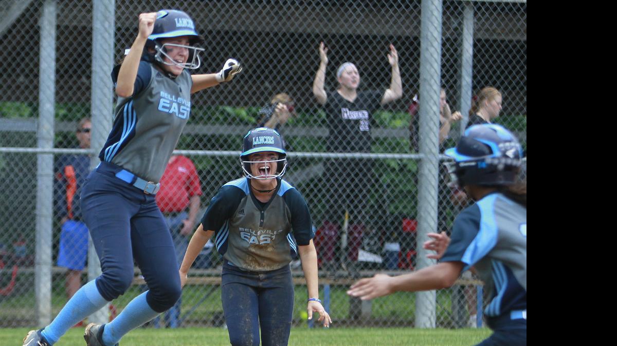 
Belleville East and Belleville West played Saturday morning to decide the regional softball championship. East won, 4-3. Here, Belleville East baserunners Rebecca Dahm (24, left) and Brooke Laidley (29, center) were congratulated by teammate Tawnee Kramer (14, right) who ran out to them as they crossed home plate. Dahm and Laidley scored off a hit by Jessica Belzer (17, not shown). 
