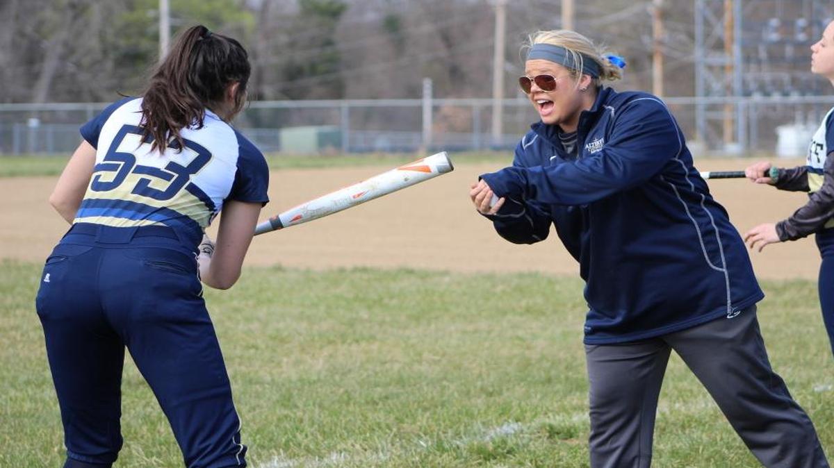 First-year Althoff softball coach Donyelle Demarse works with junior Katelynn Peterson on her swing before a game against Red Bud.