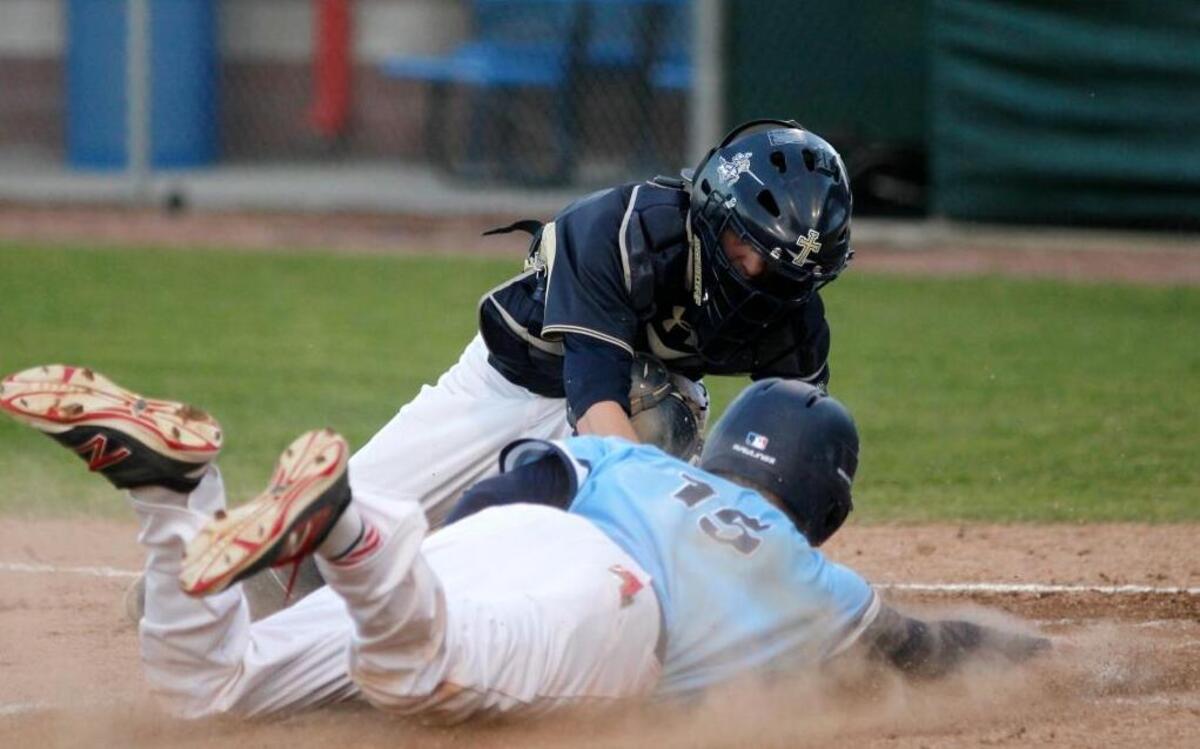 Belleville East’s Evan Gray is tagged out at home plate by Althoff’s Jack Toenjes during their game on Friday.