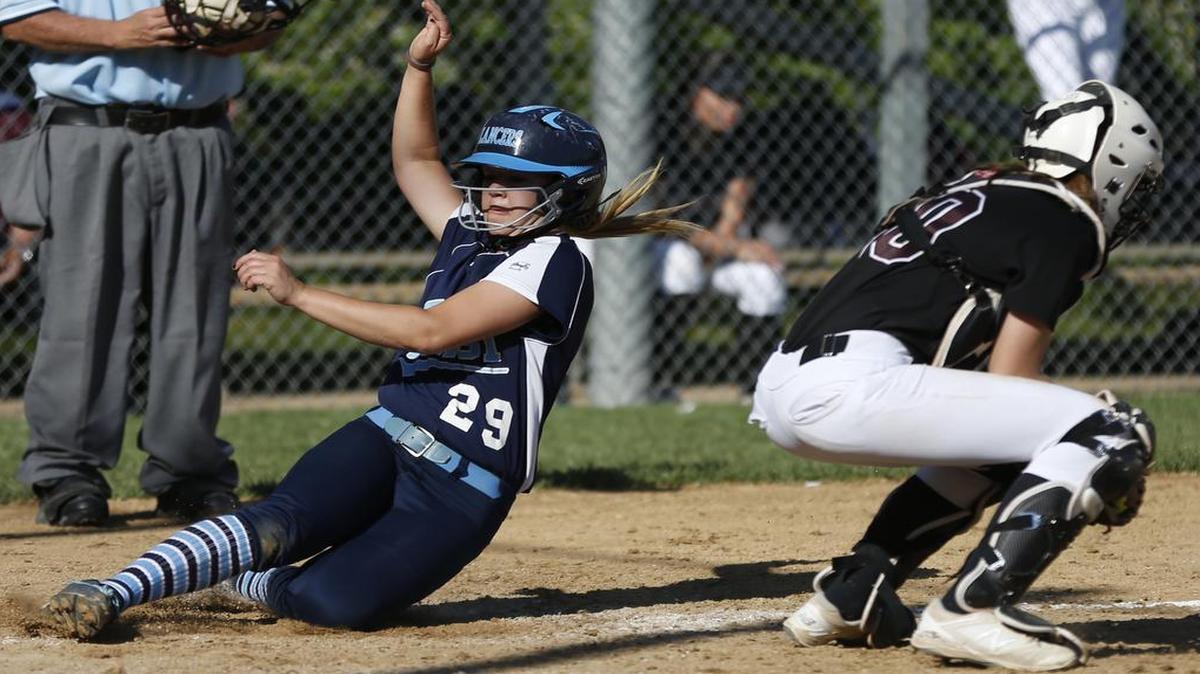 Belleville East’s Brooke Laidley slides past Belleville West catcher Aleigha Cory to score during their game on Thursday at Belleville East.