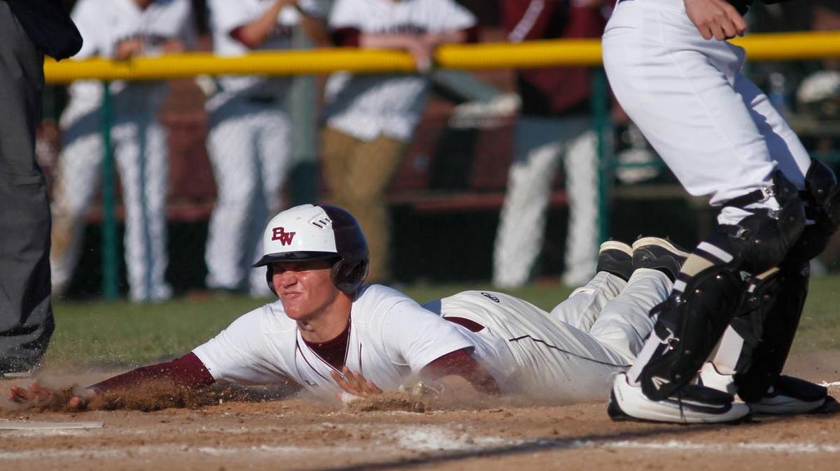 Belleville West’s Logan Betz slides home to score during the fifth inning of the Maroons’ game against Althoff on Wednesday.