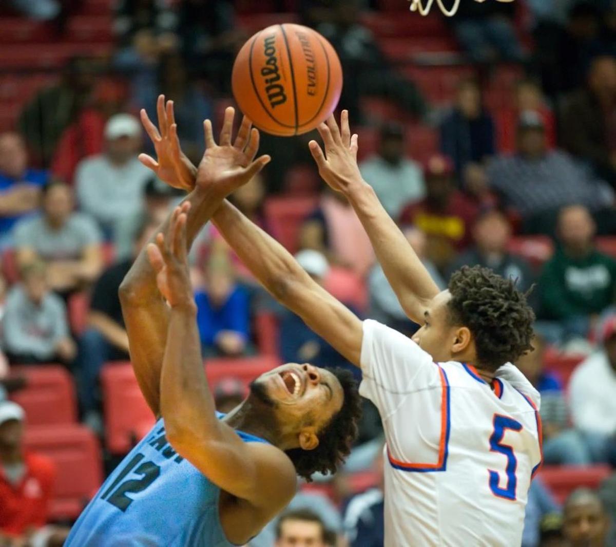 East St. Louis’ Joe Reece (5) and Belleville East’s Jordan Yates (12) battle for the ball during during Saturday’s SWC event at SIUE’s Vadalabene Center.