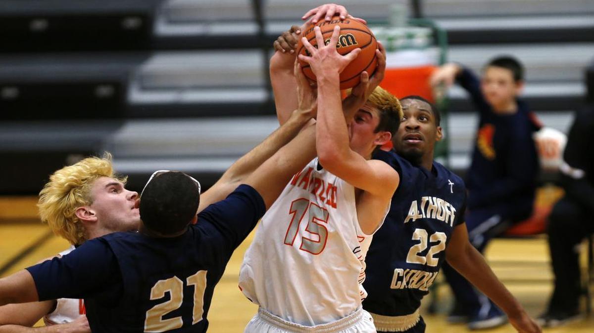 Waterloo's (12) Griffin Lenhardt and (15) Ben Huels battle Althoff's (21) Dante Ray and Brendon Gooch for a rebound during their game at the Battling Bulldog Thanksgiving Tournament at Waterloo High School on Monday.