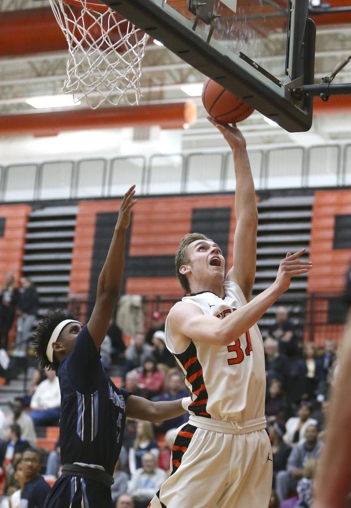 Edwardsville's Caleb Strohmeier makes a move to the basket against Belleville East's EnRico Sylvester last season.