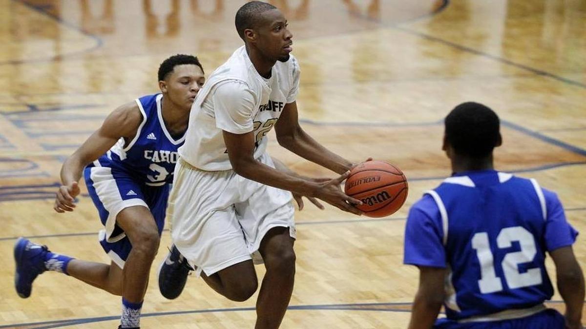 Althoff senior Brendon Gooch, in white, dribbles between a pair of Cahokia defenders during a win on Feb. 5. Gooch, who has committed to play at Southern Illinois University at Carbondale, is one of five Crusaders who average in double figures scoring.