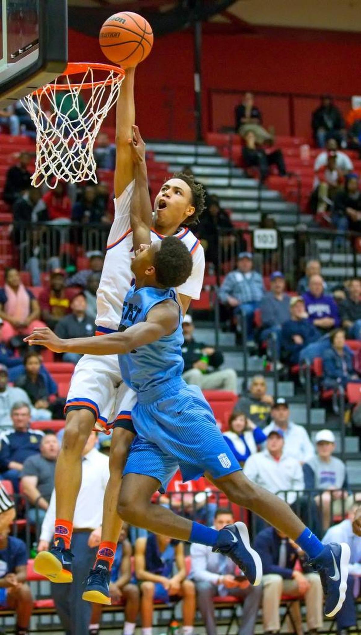 East St. Louis’ Joe Reece goes over Belleville East’s Jared Adams for the slam during Saturday’s SWC event at SIUE’s Vadalabene Center.