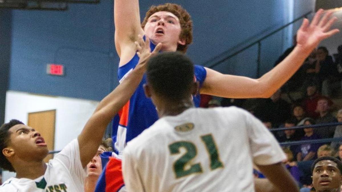 Okawville’s Noah Frederking makes a move to the hoop against Briarcrest defenders during the 54th annual Mater Dei Christmas Tournament.