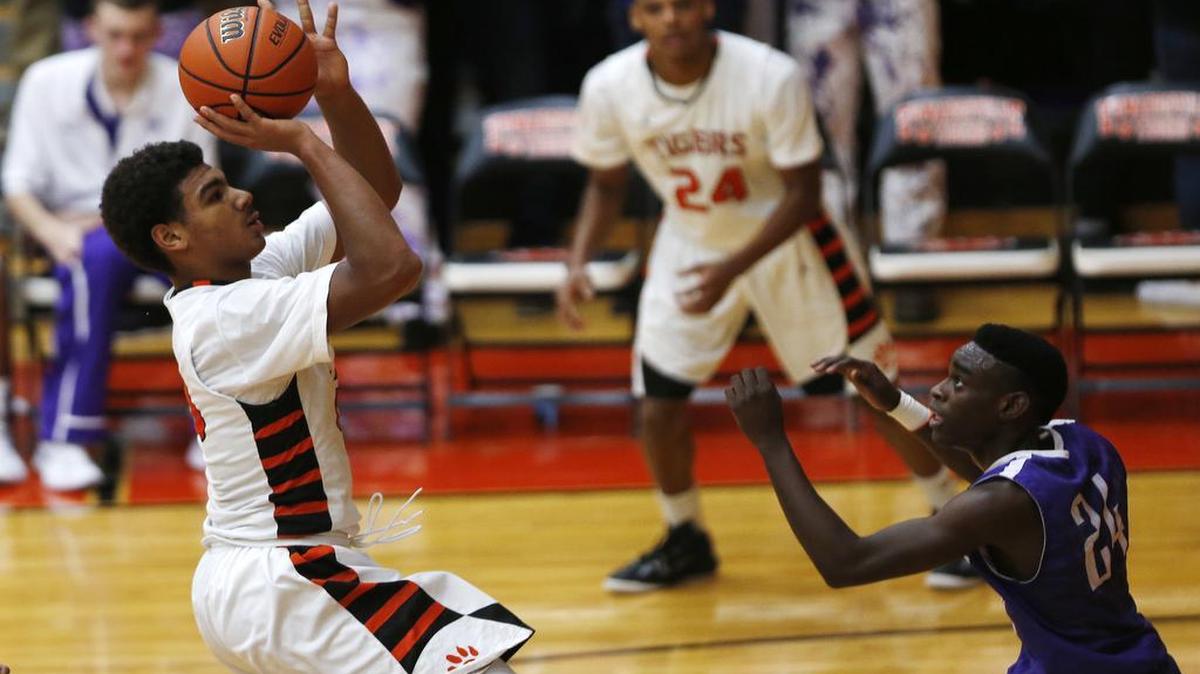 Edwardsville’s Mark Smith shoots for a basket as Collinsville’s Ronnie Midgett goes to block during their game at Edwardsville High School on Friday. See a gallery of photographs at bnd.com.