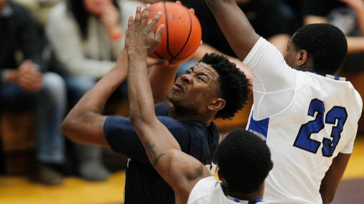Althoff's Jordan Goowin drives to the hoop past MacArthur's (24) DJ Smith and Keymonta Johnson during their championship game at the Collinsville Prairie Farms Holiday Classic on Wednesday.