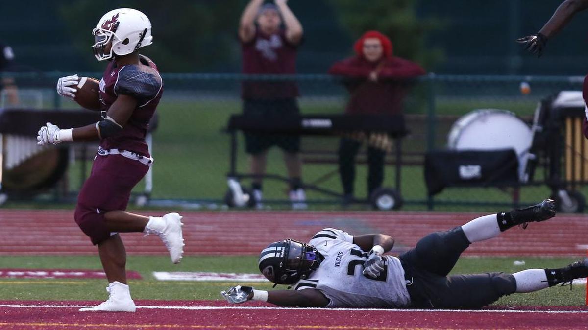 
Belleville West's Kriston Davis pulls away from Normal West's Dave Watson to score a touchdown during the first half last Friday. The Maroons will take to the road Friday, traveling to Normal Community.
