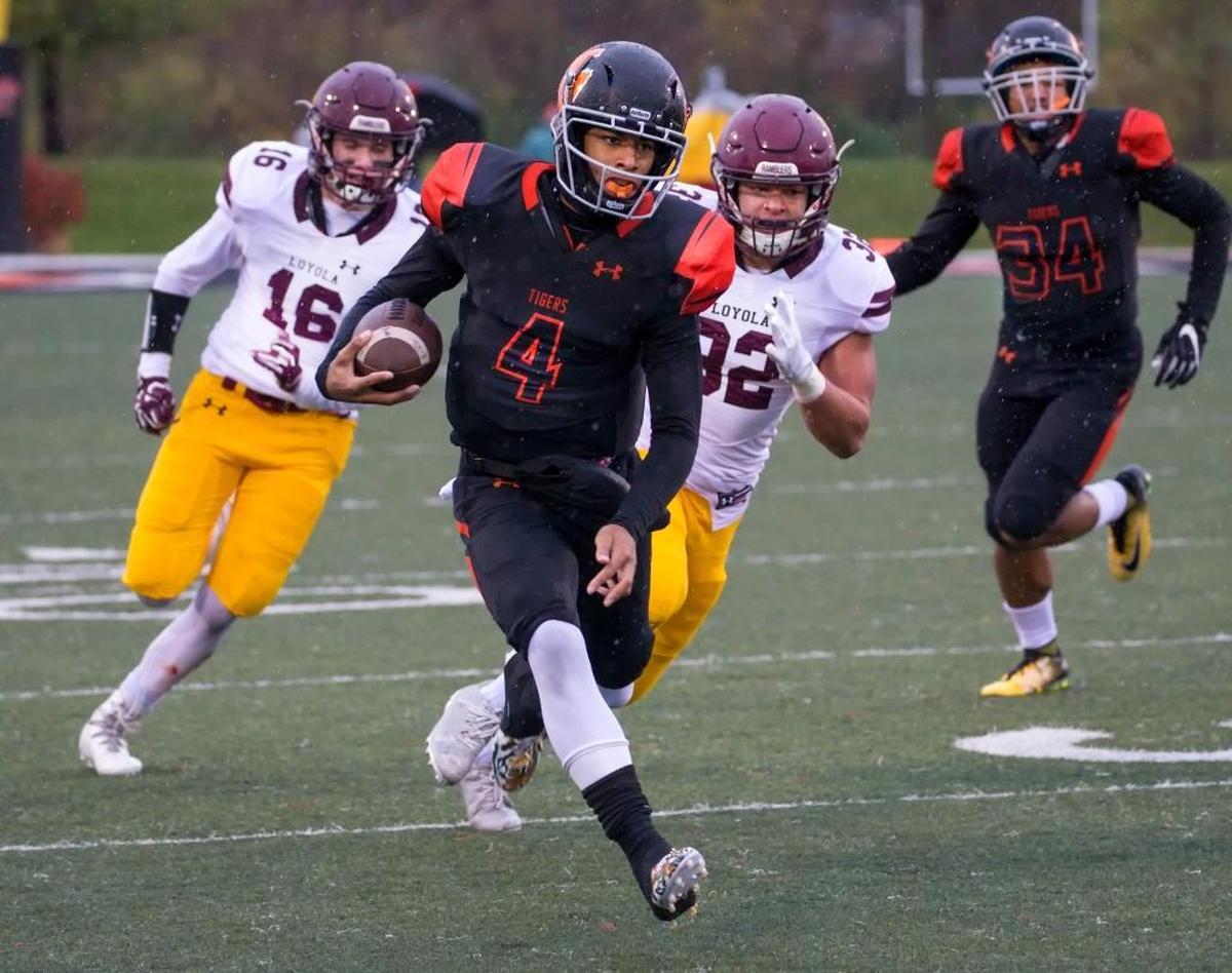 Edwardsville quarterback Kendall Abdur-Rahman runs the ball against Loyola Academy during Saturday’s semifinal game at Edwardsville High School.