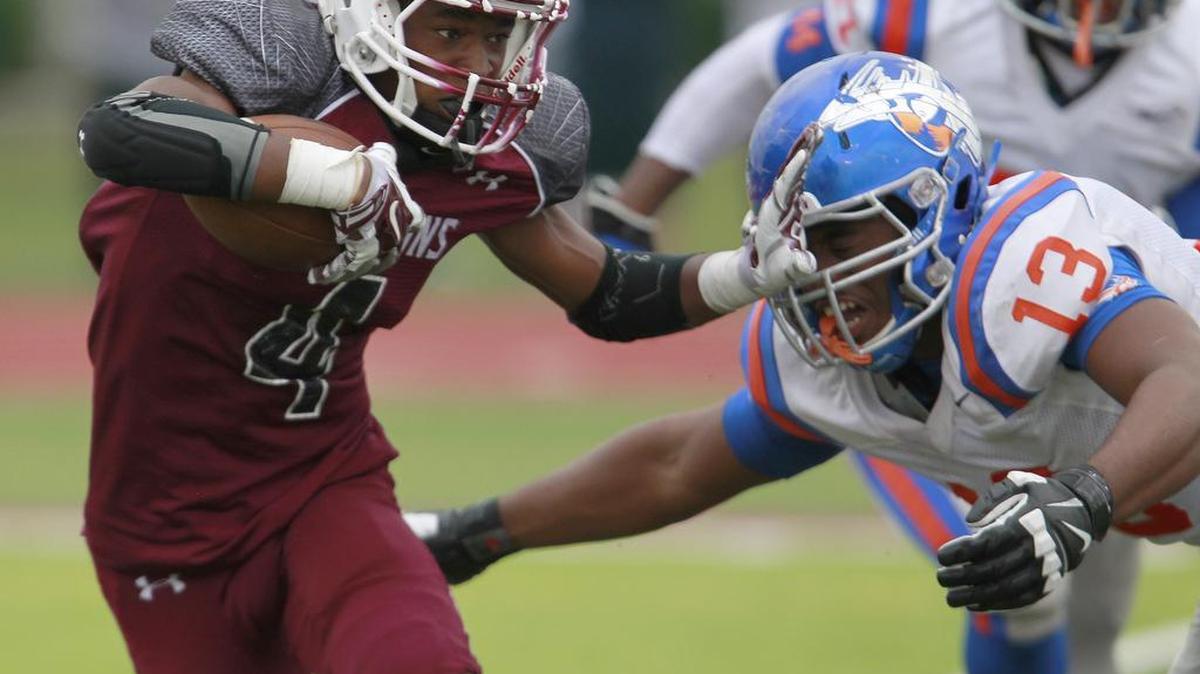 
Belleville West WR TeAntez Anthony (4, left) puts a hand to the helmet of East St. Louis LB LaMontre' Harvey (13) coming in at him from the right in this second half play. 
