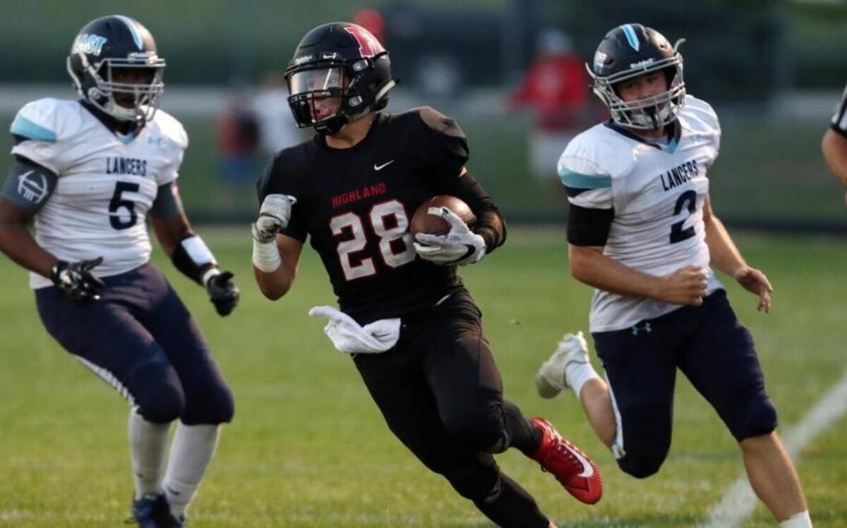 Highland junior running back Brady Feldman pulls away from Belleville tacklers in Week 1 of the 2017 season. Feldman rushed for 181 yards and two touchdowns as the Bulldogs defeated Jerseyville 42-7