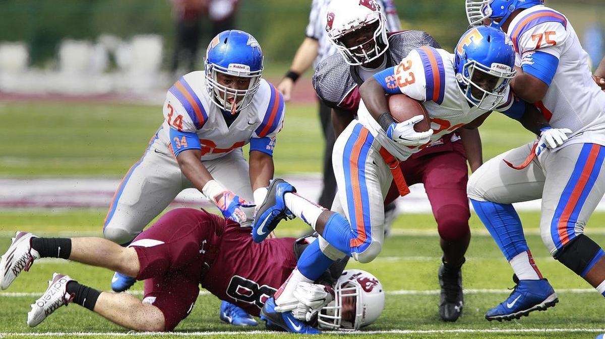 
Belleville West's Jack Lanxon (8, on turf) grabs hold of East St. Louis ballcarrier Javeon Taylor (23) as other players swarm in on the play. At far left is Flyers player Charlando Robinson (34) and at far right is Flyers player Walter Baxter (75). Behind Taylor in center is Maroons player Khari Kollore (34). 
