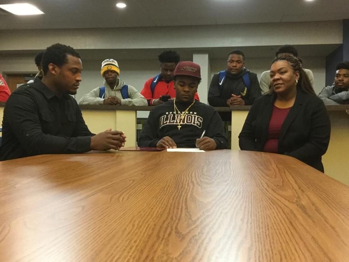 East St. Louis senior linebacker and defensive back Oliver McDowell Jr., flanked by parents Oliver McDowell Sr. and Temia Rice, signs his national letter of intent Wednesday morning to play football at Southern Illinois University Carbondale. McDowell Jr. was surrounded by many of his Flyers teammates.