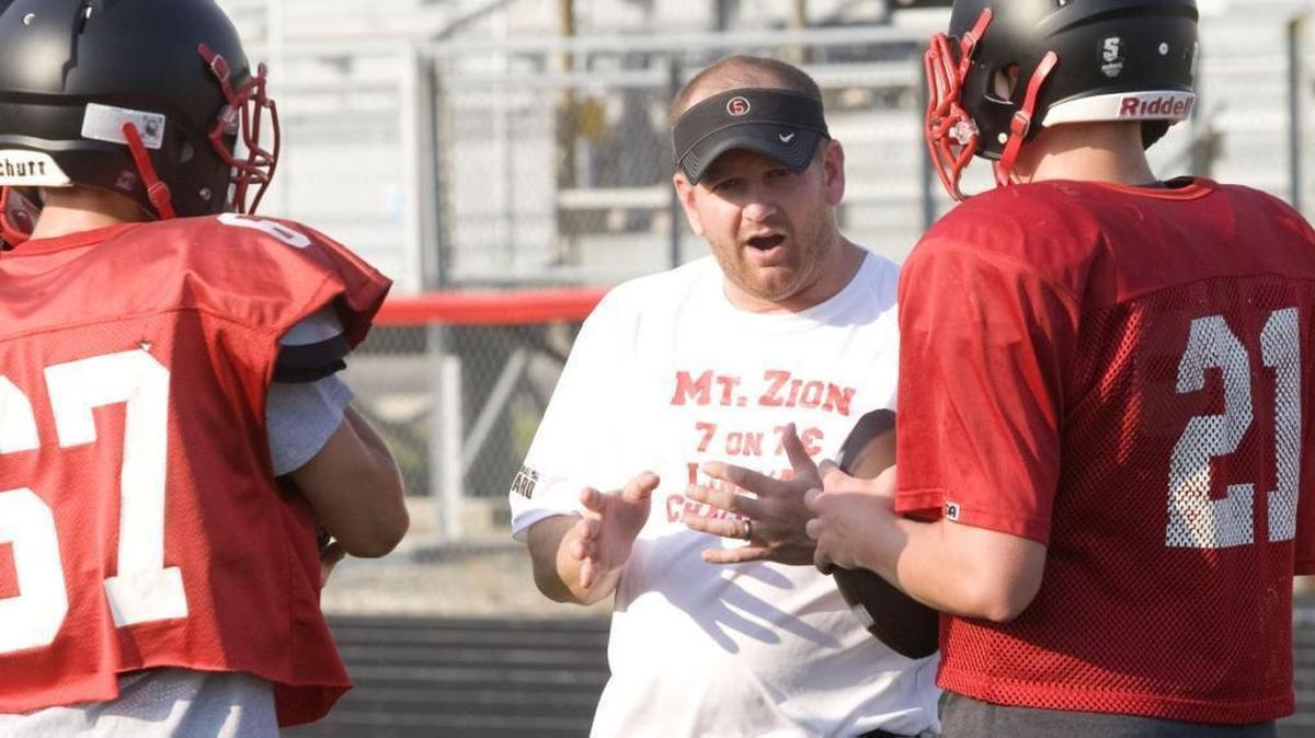 Mike Popovich (middle) is the new football coach at Collinsville High School. Popovich is shown above when he was the coach at Mount Zion High School, near Decatur.