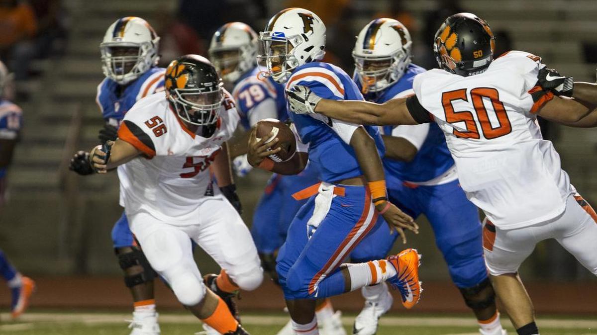 East St. Louis QB Christian Perez carries the ball during the Edwardsville at East St. Louis varsity football game at Clyde C Jordan Memorial Stadium.