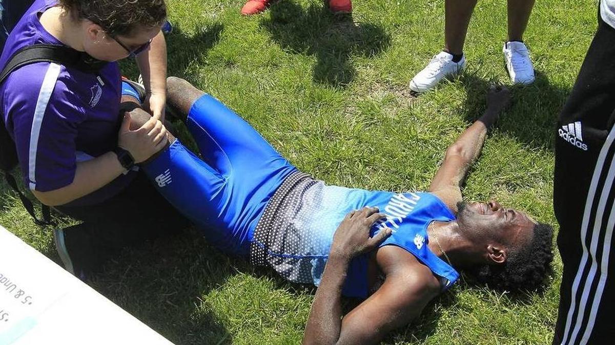 Cahokia senior and state triple jump record holder Ja’Mari Ward is checked after suffering a dislocated knee at Collinsville. Ward will bypass the final sectional meet of his career to prevent further injury.