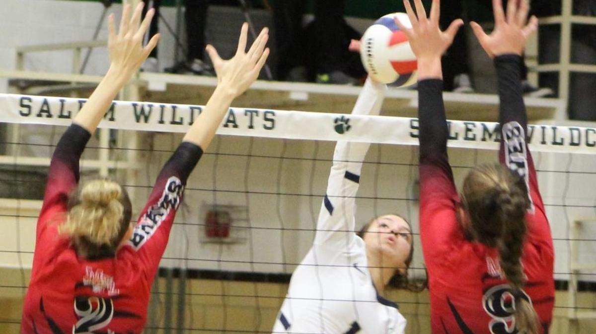 Althoff sophomore Katie Wemhoener goes up for one of her seven kills against an attempted block by Mount Zion’s Hayden Engelbrecht and Dayna Kennedy in the Salem Class 2A Volleyball Super-Sectional.