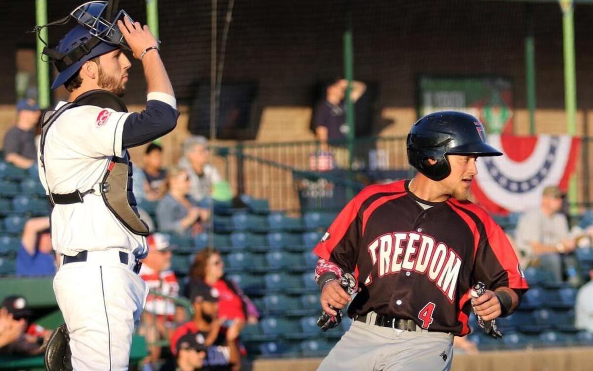 Gateway catcher Lou Iannotti awaits the thro as the Freedoms Daniel Fraga scores the first run of the game.
