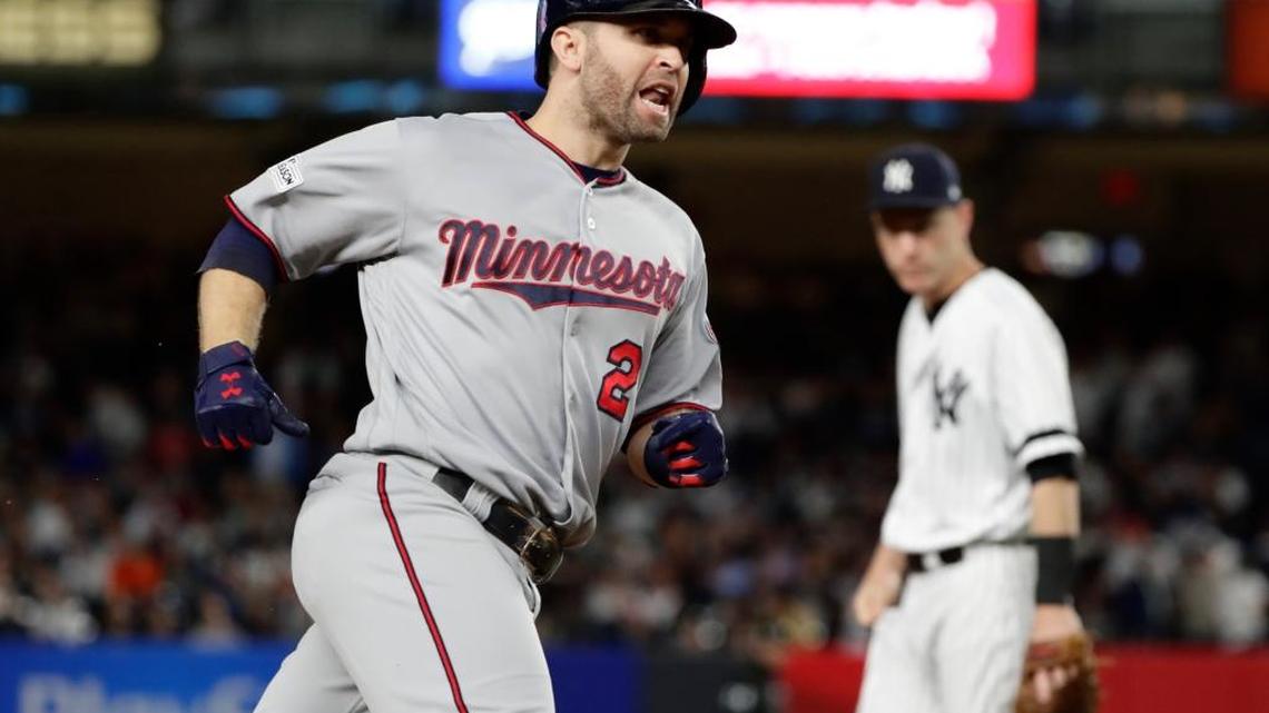 Minnesota Twins' Brian Dozier runs past New York Yankees third baseman Todd Frazier after hitting a home run during the first inning of the American League wild-card baseball playoff game Tuesday, Oct. 3, 2017, in New York.
