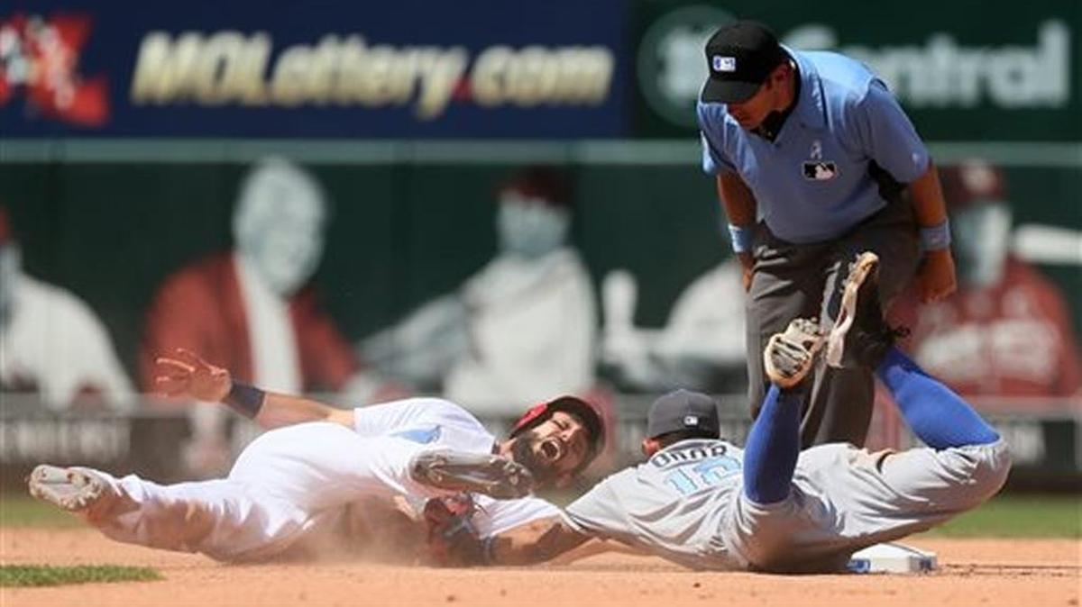 St. Louis Cardinals' Matt Carpenter, left, is tagged out by Texas Rangers second baseman Rougned Odor as he loses contact with the base after trying to stretch a single into a double in the seventh inning of a baseball game, Sunday, June 19, 2016, at Busch Stadium in St. Louis. At right is second base umpire Mark Ripperger. (Chris Lee/St. Louis Post-Dispatch via AP)