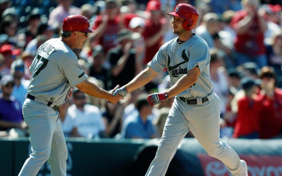 St. Louis Cardinals third base coach Chris Maloney, left, congratulates pinch-hitter Paul DeJong who circles the bases after hitting a solo home run off Colorado Rockies relief pitcher Greg Holland in the ninth inning of a baseball game Sunday, May 28, 2017, in Denver.