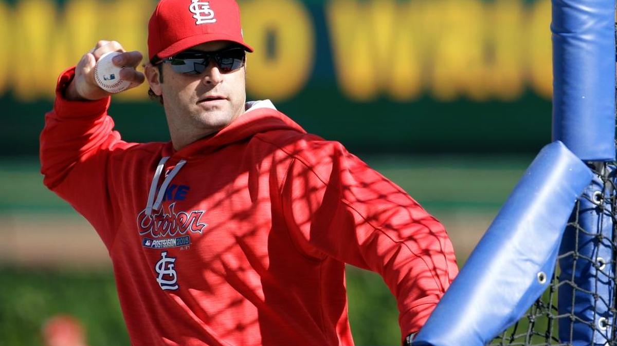 St. Louis Cardinals manager Mike Matheny throws a ball during an NLDS baseball practice on Sunday in Chicago.