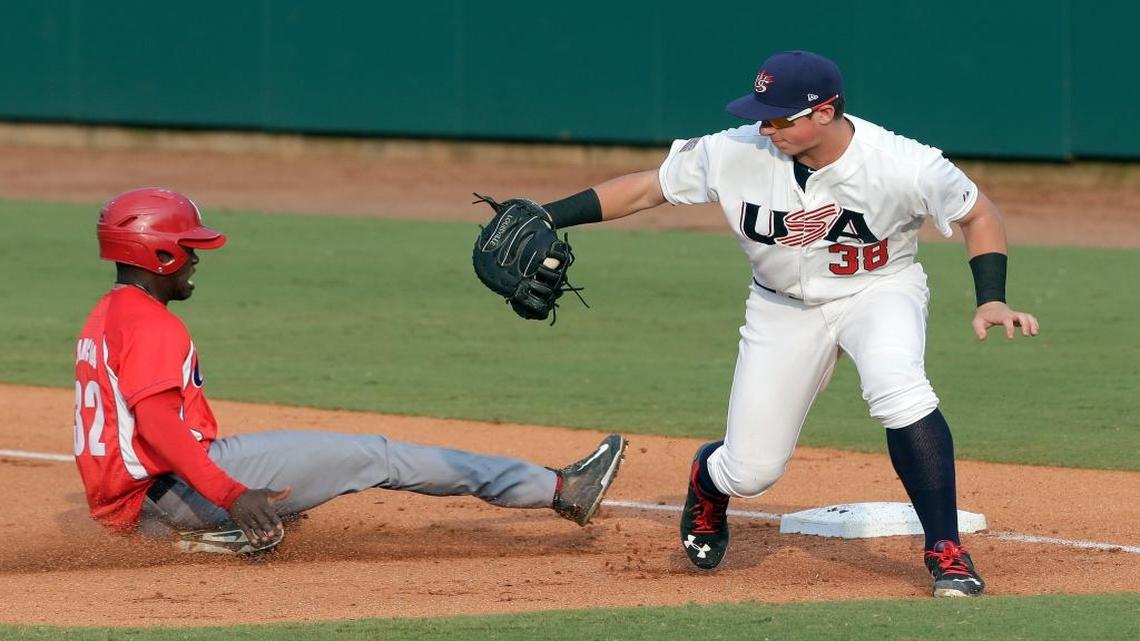 U.S. collegiate team first baseman Brendan McKay (38) reaches for the throw as Cuba's Jose Adolis Garcia Arrieta (32) slides safely back to first base during the first inning of a baseball game in Cary, N.C., Monday, July 6, 2015.