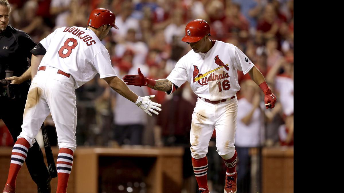 
The Cardinals’ Kolten Wong is congratulated by Peter Bourjos after hitting a solo home run off the Tigers’ Alfredo Simon with one out in the bottom of the sixth inning Sunday at Busch Stadium.
