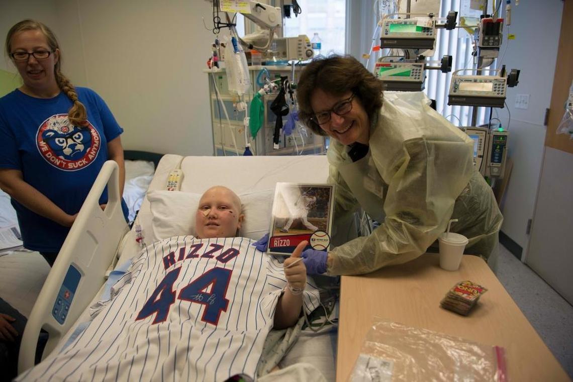 Abby Schrage, 12, of Highland accepts a Chicago Cubs jersey autographed by Chicago Cubs’ first baseman Anthony Rizzo. The jersey arrived in the mail at St. Louis Children’s Hospital Wednesday and was presented by hospital president Joan Magruder. Abby’s mom, Jill, stands by to the left. Abby has been in the pediatric intensive care unit at Children’s for 29 days following bone marrow transpant to combat cancer.