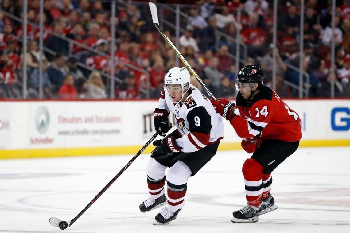 Arizona Coyotes center Clayton Keller (9) controls the puck past the New Jersey Devils’ Adam Henrique during a game Saturday in Newark, N.J. Keller, a Swansea native, has been named the National Hockey League’s Rookie of the Month for October.